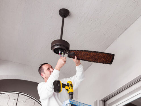 Homeowner performing DIY ceiling fan installation