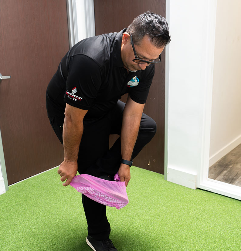 Temp Air System employee showing community support for breast cancer awareness with pink floor protecting booties